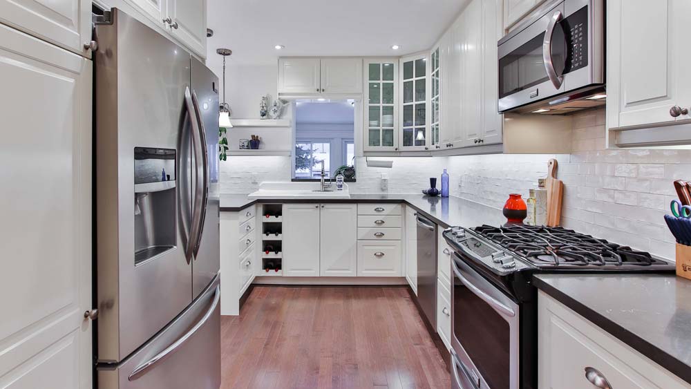 A kitchen with a refrigerator, dishwasher, and microwave.